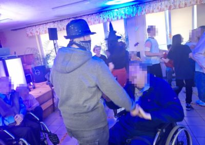Wychowanka tańczy z podopiecznym DPS który porusza się na wózku inwalidzkim