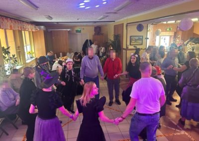 Wychowanki tańczą w kółku z pensjonariuszami